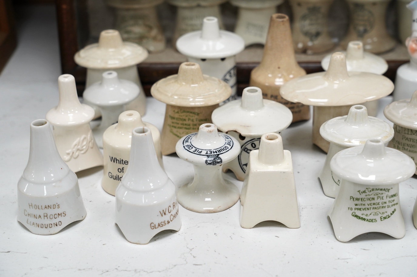 Approximately fifty assorted Victorian pottery pie funnels, some contained within a mahogany display case. Condition - varies